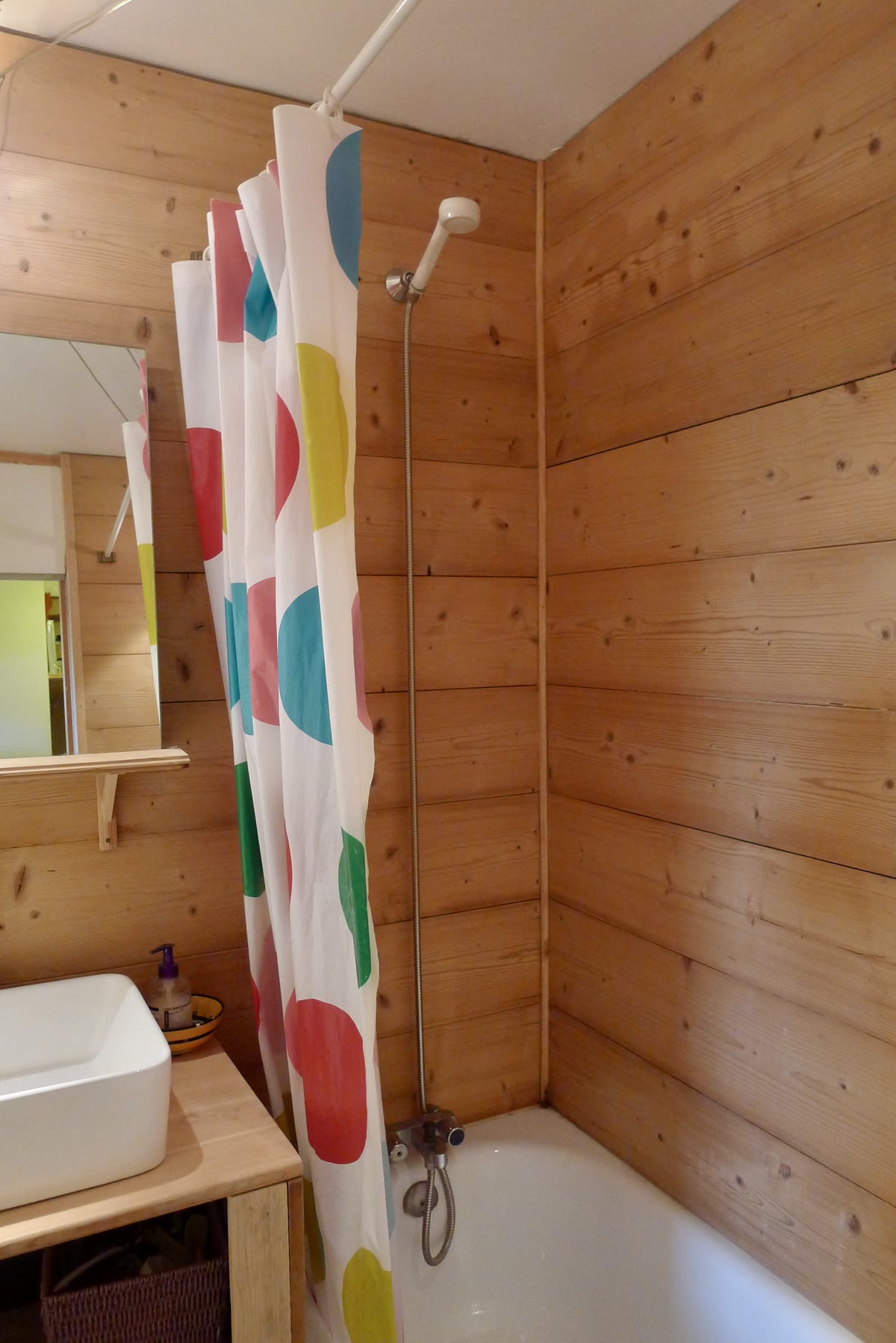 Wood-panelled bathroom with bath and shower